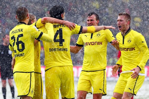 Männer in gelber Sportuniform spielen Fußball