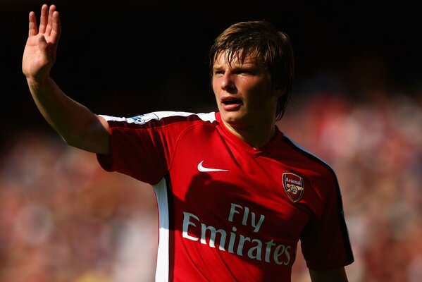 Arshavin in una maglietta rossa agita la mano