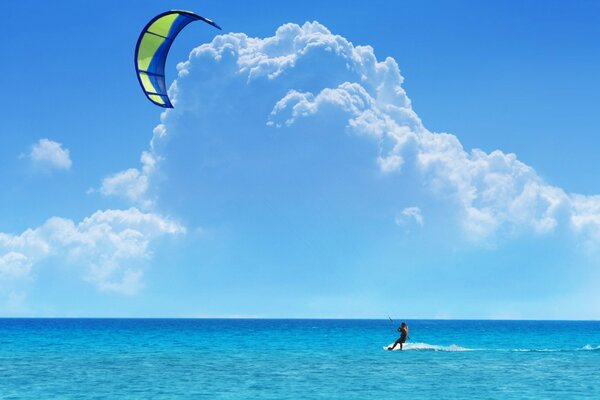 Surfing and kiting on the background of the azure sky and the endless sea