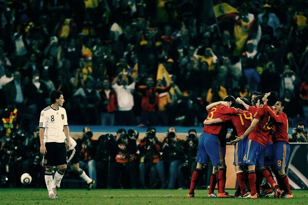 Match de football avec un stade complet de fans. Les joueurs de football se tiennent sur le terrain, embrassant