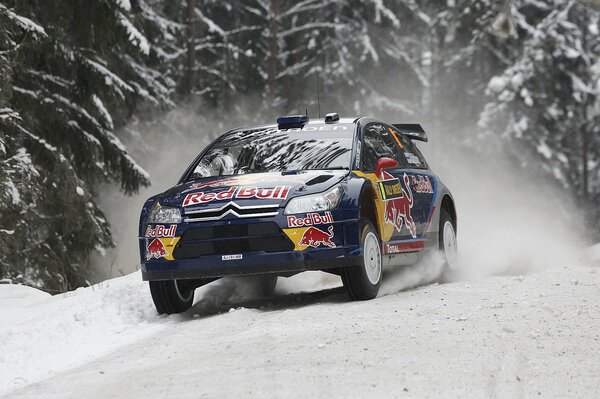 Rallye auf einer verschneiten Straße mit einem blauen Auto