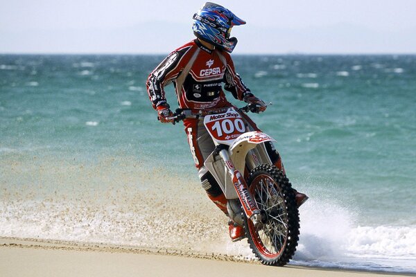 Motociclista su una moto sulla costa sabbiosa