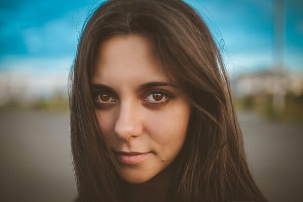 Fille aux yeux bruns regarde la caméra. Portrait