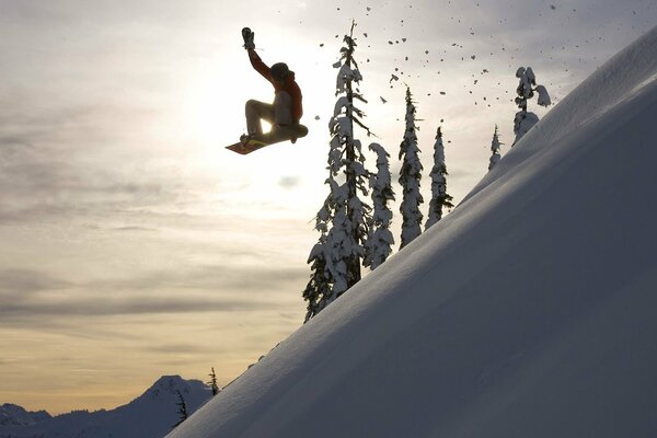 Extremer Sprung eines Snowboarders vor dem Hintergrund der Wintersonne