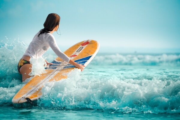 L immagine mostra le onde, l oceano, una ragazza che conosce bene lo sport