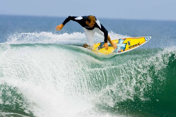 Surfer na grzbiecie turkusowej fali