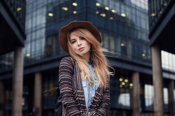 Fille au chapeau sur fond de bâtiments