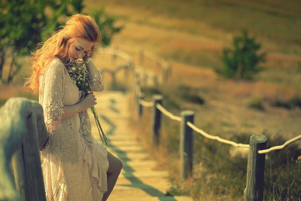 Red-haired girl on the village bridge