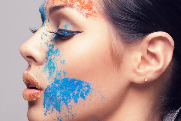 Fille avec de faux cils et maquillage multicolore