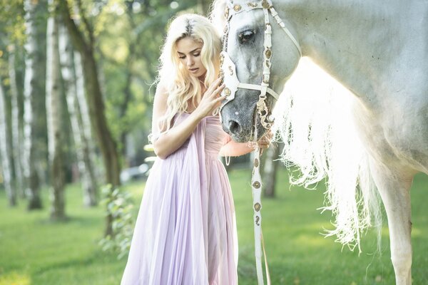 Chica alrededor de un caballo en un vestido