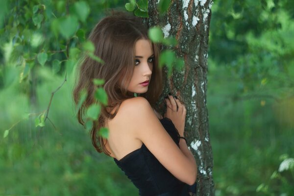 A girl in the forest among green trees