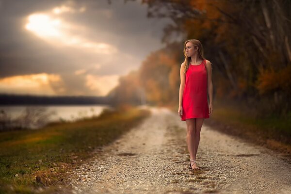 Cute girl in a dress on the road in autumn