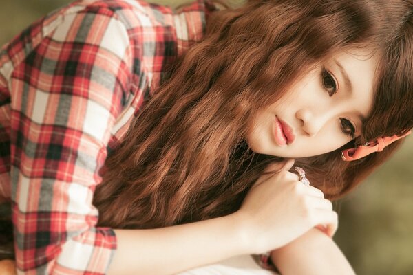 Photo of a young thoughtful brown-haired Asian woman