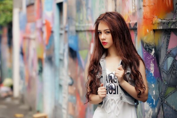 Chica de pelo largo contra la pared con graffiti