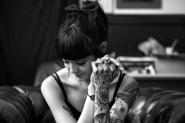 Hannah Snowden is a brunette model in black and white background with tattoos on her arms