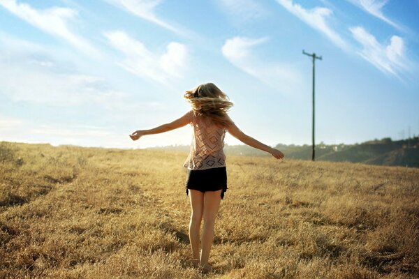 Chica dando vueltas en el campo