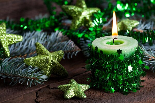 Candle flame on the background of Christmas decorations