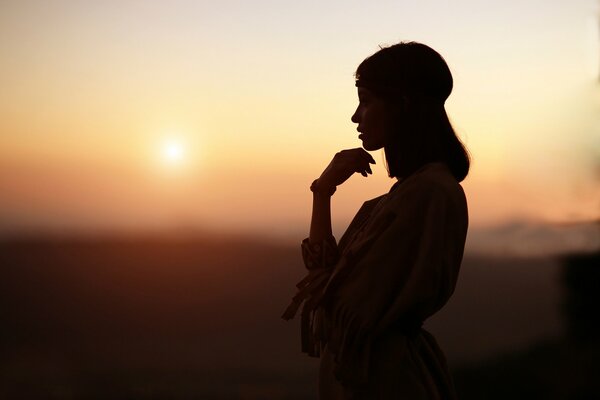 Silhouette eines Mädchens bei Sonnenuntergang