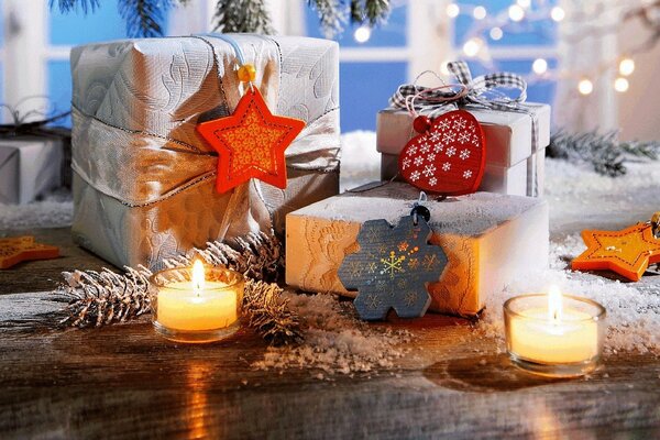 Christmas gifts surrounded by candles and fir cones