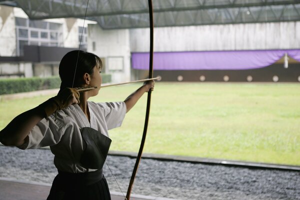 A girl pulling a bowstring on a bow