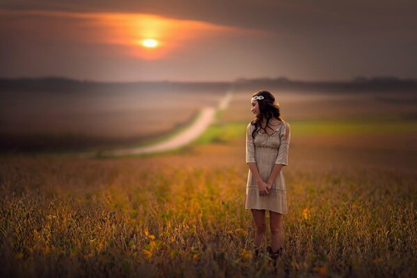 A girl in a field of flowers at sunset