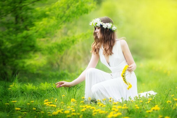 La ragazza raccoglie i denti di leone in una corona