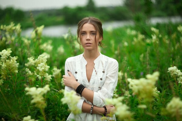 A young girl in a blooming summer field