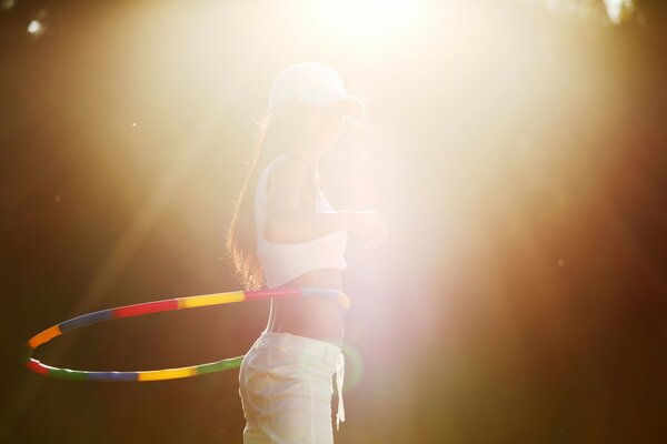 Fille avec un cerceau dans la lumière du soleil