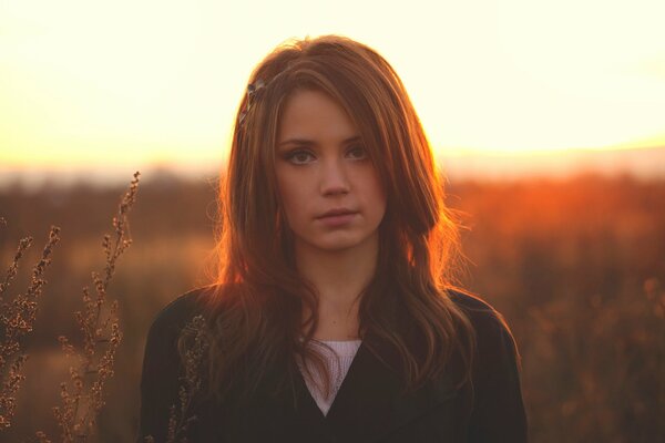 Brüstendes Foto von Xenia Kokoreva vor dem Hintergrund der Natur bei Sonnenuntergang