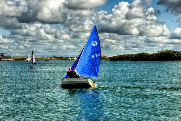 Sailboats in blue volya against a cloudy sky