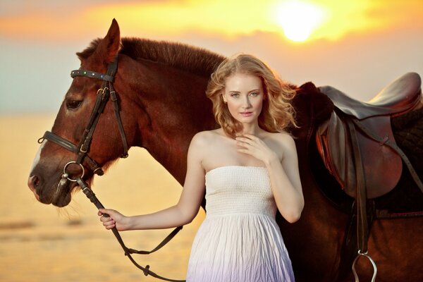 Jeune fille avec un cheval sur le rivage