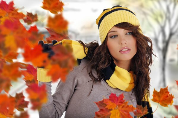 Ragazza tra le foglie volanti degli alberi