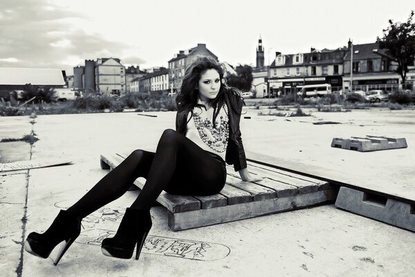 Brunette girl in heels on the background of the city