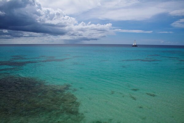 Mar sereno y yate en el horizonte