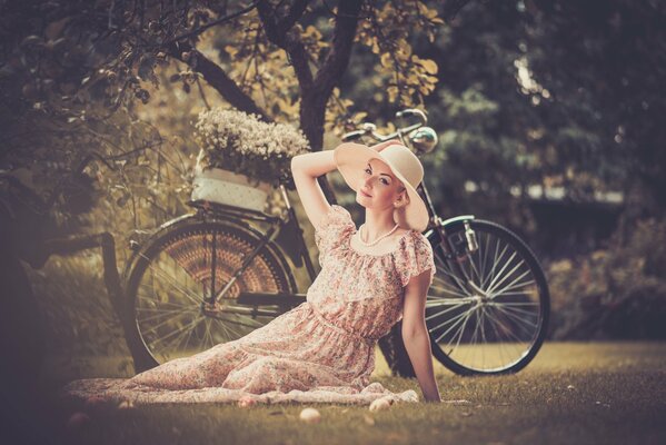 Chica con sombrero se toma una foto con una bicicleta