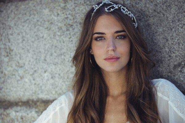 Fille avec boucles d oreilles se dresse sur fond de mur