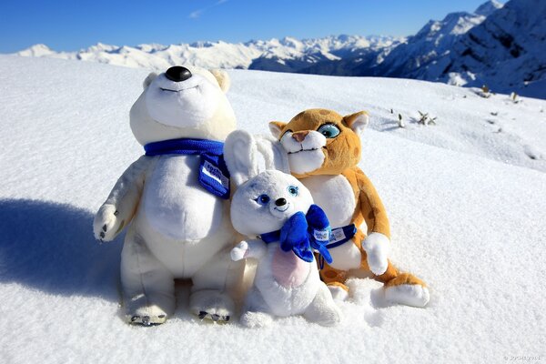 Olympic mascots are sitting in the snow