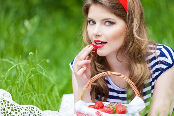 Fille blonde mange des fraises