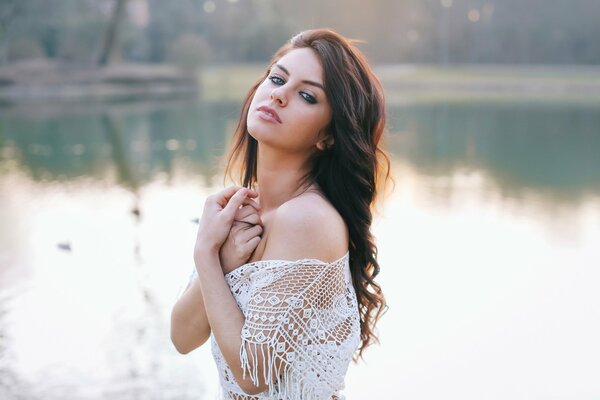 A girl on the background of a lake in a mesh T-shirt