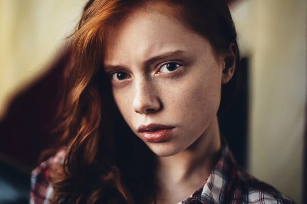 Portrait of a red-haired girl with freckles