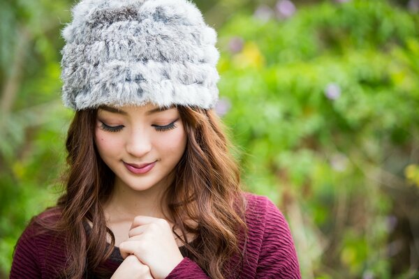 Fille asiatique dans un chapeau dans le parc