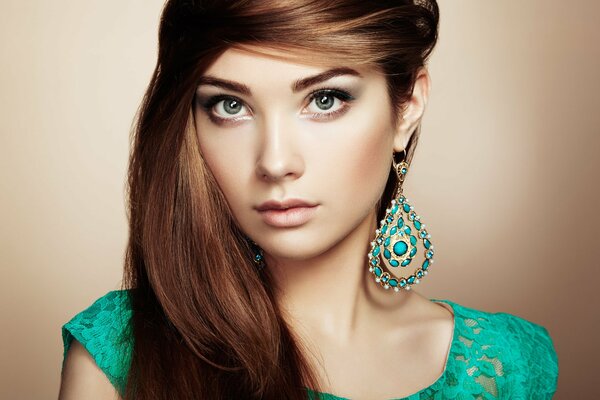 Brunette with green earrings and a green dress