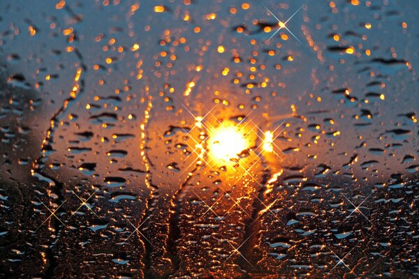 Gouttes de pluie et coucher de soleil sur le verre