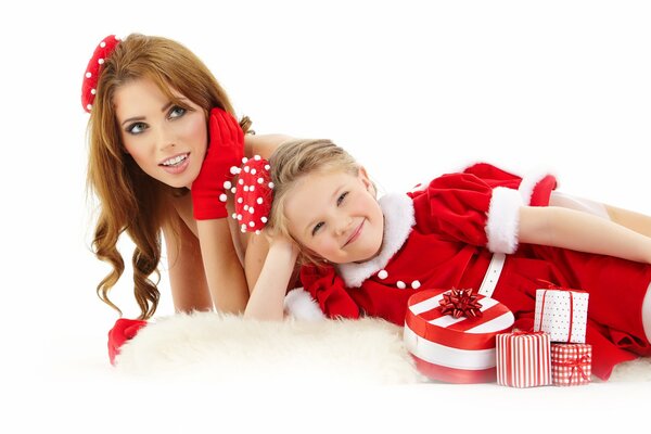 Niña y niña en trajes de año nuevo posando con cajas festivas