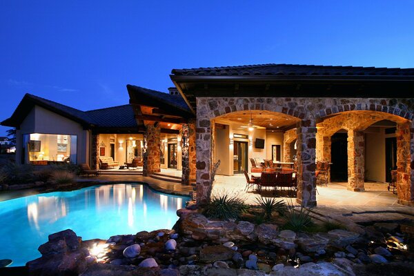 A house with a swimming pool in the style of stone. Inside the TV