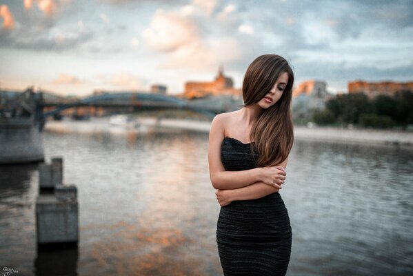 Catalina de la Asunción. La chica del vestido negro en el puente del agua junto al río