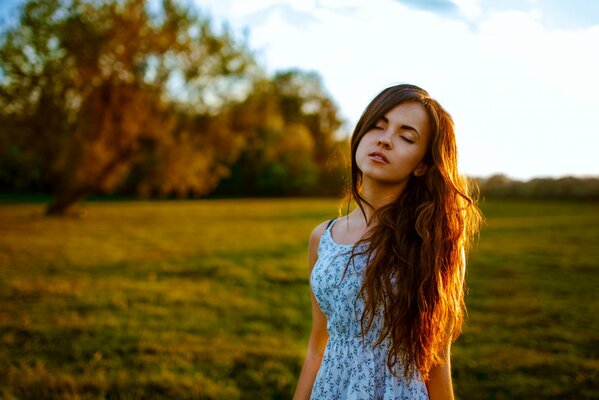 Chica con el pelo largo y los ojos cerrados de pie en el Prado