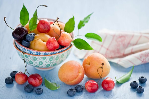 Nature morte de baies et de fruits avec des bols et une serviette