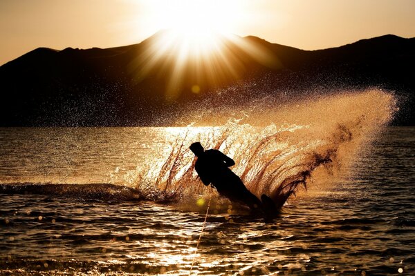 A man on water skis at sunset