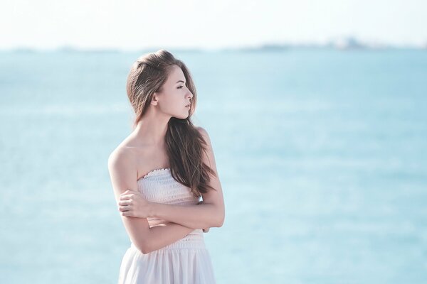 Ragazza in piedi accanto al mare blu